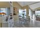 Bright dining area with a glass table, decorative shelves, and modern furnishings, seamlessly flowing into the living space at 13791 Palmetto Point Ct, Port Charlotte, FL 33953