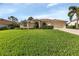 Charming single-story home with a manicured lawn, tile roof, and attached two-car garage at 13791 Palmetto Point Ct, Port Charlotte, FL 33953