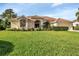 Well-maintained single-story home with a lush green lawn, featuring a tile roof and manicured landscaping at 13791 Palmetto Point Ct, Port Charlotte, FL 33953