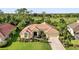 Inviting single-story home featuring a tile roof, lush landscaping, and views of a golf course in the distance at 13791 Palmetto Point Ct, Port Charlotte, FL 33953