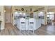 Open-concept kitchen featuring white cabinets, a breakfast bar with seating, and modern countertops with wood grain flooring at 13791 Palmetto Point Ct, Port Charlotte, FL 33953
