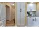 Kitchen area with a refrigerator, pantry, and white cabinets, complemented by granite countertops and wood flooring at 13791 Palmetto Point Ct, Port Charlotte, FL 33953