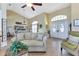 Open-concept living room with tiled floors, a comfortable couch, and large windows that provide natural light at 13791 Palmetto Point Ct, Port Charlotte, FL 33953