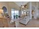 Bright living room featuring a cozy seating area, tiled floors, and a sliding glass door leading to the outdoors at 13791 Palmetto Point Ct, Port Charlotte, FL 33953