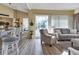 Inviting living room with neutral furniture, sliding glass doors to the pool, and a seamless connection to the dining area at 13791 Palmetto Point Ct, Port Charlotte, FL 33953