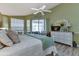 Bright main bedroom with ceiling fan, slider to lanai, and dresser with decor at 13791 Palmetto Point Ct, Port Charlotte, FL 33953