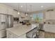 Modern kitchen with white cabinets, stainless steel appliances and large island at 13808 Posada St, Venice, FL 34293