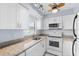 Updated kitchen with white shaker cabinets, granite countertops, and stainless steel appliances at 304 47Th Avenue W Dr # 307, Bradenton, FL 34207