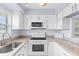 White kitchen with granite countertops, white appliances, and ample cabinet space at 304 47Th Avenue W Dr # 307, Bradenton, FL 34207