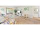 Living room with wood-look flooring, a white entertainment center, and sliding glass doors to a balcony at 304 47Th Avenue W Dr # 307, Bradenton, FL 34207