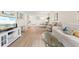 Living room with wood-look flooring, a white sofa, and a view of the dining area at 304 47Th Avenue W Dr # 307, Bradenton, FL 34207