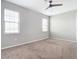 Well-lit bedroom with neutral walls, carpet, ceiling fan and two windows at 126 Porta Vecchio Bnd # 202, North Venice, FL 34275