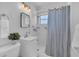 Clean bathroom with a walk-in shower and striped shower curtain at 21306 Hepner Ave, Port Charlotte, FL 33952