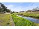 A backyard canal with lush greenery and a well-maintained landscape at 2232 River Ridge Dr, Sarasota, FL 34239