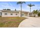 Charming single-story home with stucco and stone accents, palm trees, and a circular driveway at 2232 River Ridge Dr, Sarasota, FL 34239