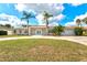 Beautiful one-story home with a circular driveway, well-manicured lawn, and lush tropical landscaping at 2232 River Ridge Dr, Sarasota, FL 34239