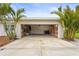 Open garage showcasing laundry, shelving and a concrete driveway framed by palm trees at 2232 River Ridge Dr, Sarasota, FL 34239