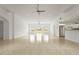 Bright and airy living room with neutral tile flooring and a view into the kitchen and backyard at 2232 River Ridge Dr, Sarasota, FL 34239
