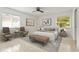 Inviting main bedroom with two accent chairs, a stylish bed, warm lighting, and large windows at 2232 River Ridge Dr, Sarasota, FL 34239