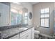 Bright bathroom with white cabinets, granite countertops, and decorative mirror at 8933 Isabella Cir, Parrish, FL 34219