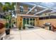 Outdoor patio with built-in grill, covered seating area, and lush landscaping at 7676 Bergamo Ave, Sarasota, FL 34238