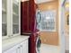 Laundry room with stacked red washer and dryer, and white cabinets at 7676 Bergamo Ave, Sarasota, FL 34238