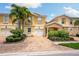 Front view of two-story townhouses with attached garages and landscaped yards at 7676 Bergamo Ave, Sarasota, FL 34238