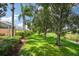 Landscaped backyard with lush greenery, mature trees, and tranquil waterway view at 7676 Bergamo Ave, Sarasota, FL 34238