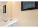 Simple bathroom with white vanity and a framed picture at 7676 Bergamo Ave, Sarasota, FL 34238