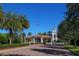 Gated entrance with guardhouse, clock tower, and lush landscaping at 7676 Bergamo Ave, Sarasota, FL 34238