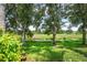 Landscaped backyard with lush greenery, mature trees, and tranquil waterway view at 7676 Bergamo Ave, Sarasota, FL 34238