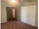 Bright bedroom with carpet, a mirrored closet door, and sliding glass doors at 4210 66Th Street W Cir, Bradenton, FL 34209