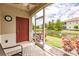 Screened patio with lake view and red door access at 8269 Enclave Way # 103, Sarasota, FL 34243