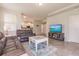 Open living room with leather sofas and view of kitchen at 8269 Enclave Way # 103, Sarasota, FL 34243