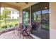 Enjoy this screened patio with two wicker chairs and a small table at 8269 Enclave Way # 103, Sarasota, FL 34243