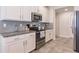 Modern kitchen with white cabinets, granite counters, and stainless steel appliances at 8269 Enclave Way # 103, Sarasota, FL 34243