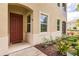 Townhome entrance with a red door, landscaping, and walkway at 8269 Enclave Way # 103, Sarasota, FL 34243