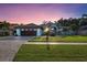 Charming home featuring a paver driveway, lush lawn, tropical landscaping, and a 2-car garage at 4888 Oak Pointe Way, Sarasota, FL 34233