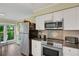 Modern kitchen with stainless steel appliances, granite countertops, and white cabinets at 3413 Clark Rd # 114, Sarasota, FL 34231