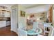 Casual dining area with glass-top table and white chairs, kitchen view at 3413 Clark Rd # 114, Sarasota, FL 34231