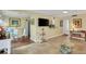 Bright living room with tile floors, glass coffee table, and a view into the kitchen and dining area at 3413 Clark Rd # 114, Sarasota, FL 34231