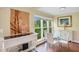 Charming dining area with glass table and four white chairs, hardwood floors and a window view at 3413 Clark Rd # 114, Sarasota, FL 34231