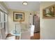 Small dining area with a glass-top table and four white chairs near a window at 3413 Clark Rd # 114, Sarasota, FL 34231