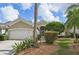 Tan house with a white garage door and landscaping at 7217 Churston Ln, University Park, FL 34201