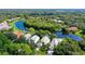 Aerial view of a house near the water, lush landscaping, and other homes at 7217 Churston Ln, University Park, FL 34201