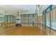 Well-lit exercise room with hardwood floors and mirrors at 7217 Churston Ln, University Park, FL 34201