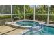 Relaxing spa with blue tile accents and a view to nature at 7217 Churston Ln, University Park, FL 34201