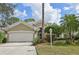 Tan house with a white garage door and landscaping at 7217 Churston Ln, University Park, FL 34201