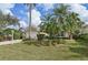 Tan house with a white garage door and landscaping at 7217 Churston Ln, University Park, FL 34201