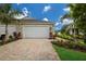 Two-car garage with paver driveway and tropical landscaping at 10748 Klee Ave, Bradenton, FL 34212